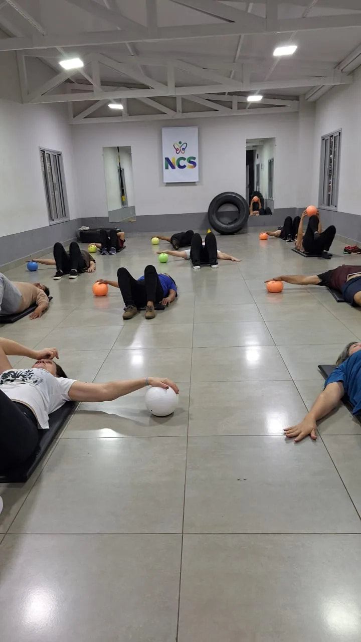 Idosos deitados em colchonetes durante avaliação de mobilidade em grupo.